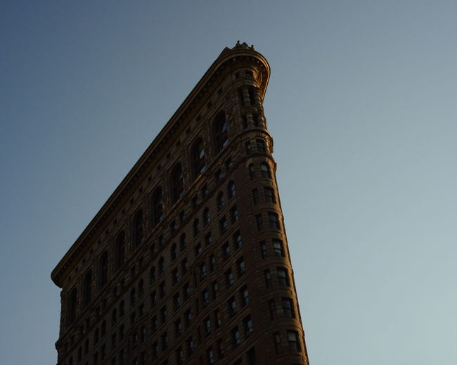 Low angle view of flatiron building against clear sky at manhattan in city