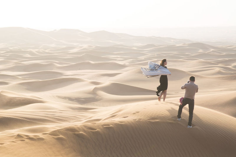 Rear view of women on sand dune in desert