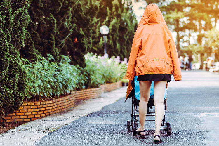 Rear view of woman with baby stroller