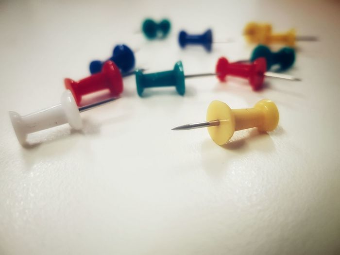 Close-up of multi colored thumbtacks on table