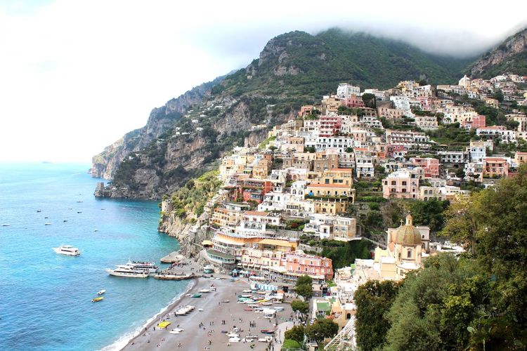 High angle view of townscape by sea against sky