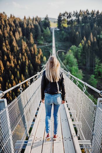 Rear view of woman standing on footbridge