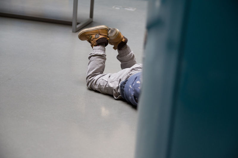 Low section of boy lying on floor
