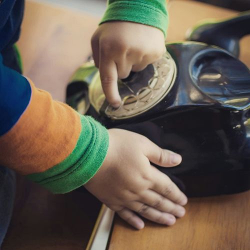 Cropped image of kid spinning rotary phone