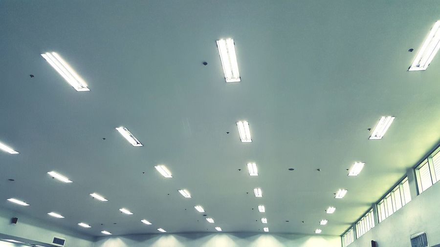 Low angle view of illuminated lights on ceiling in building