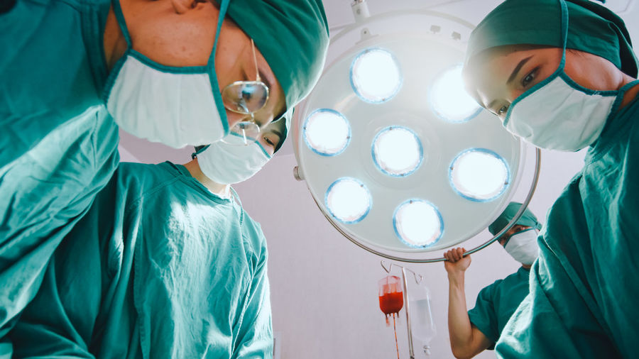 Low section of surgeons working in operating room