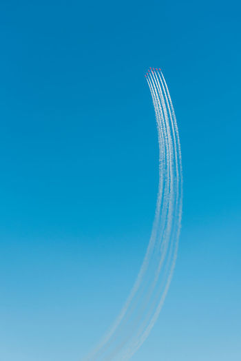 Low angle view of fighter planes flying against clear blue sky