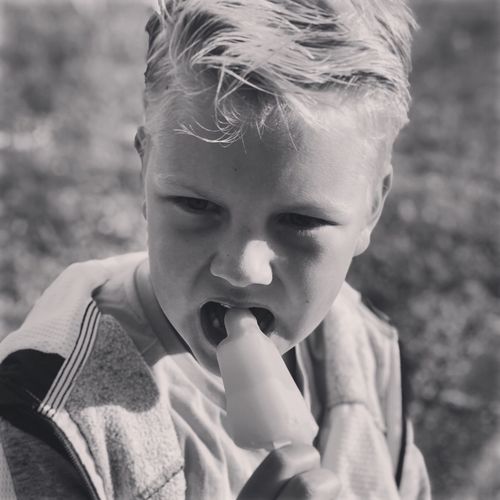 Close-up portrait of boy eating popsicle 