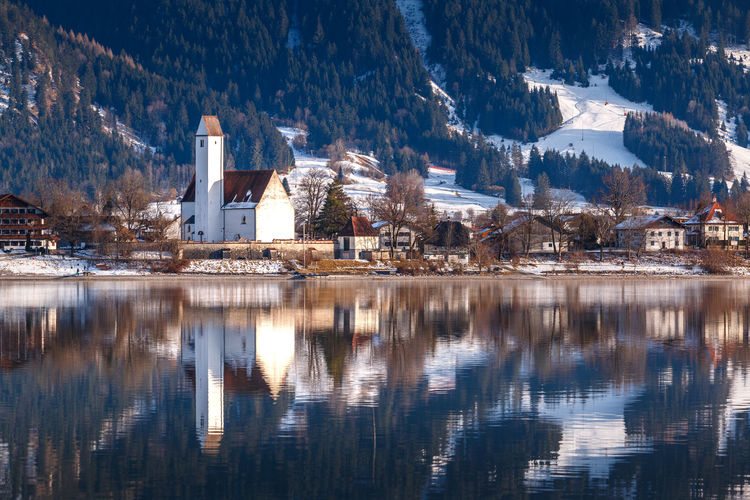Reflection of buildings in lake during winter