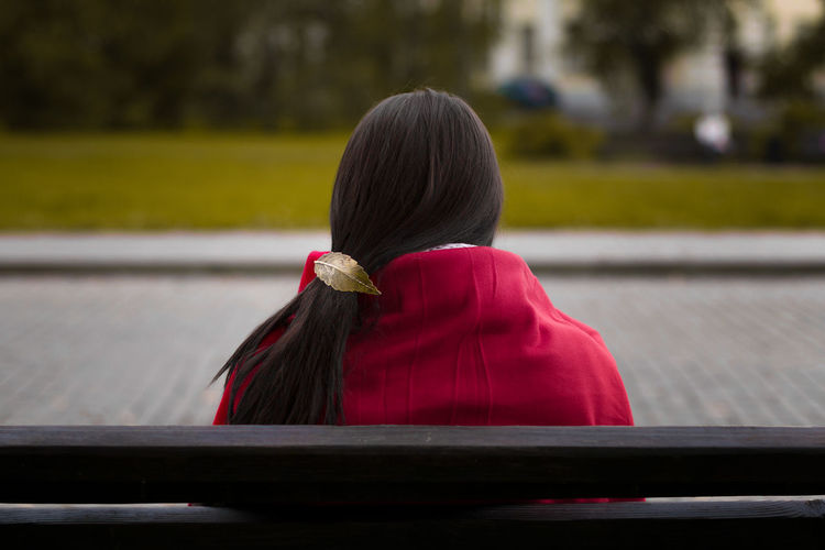 Rear view of woman sitting outdoors