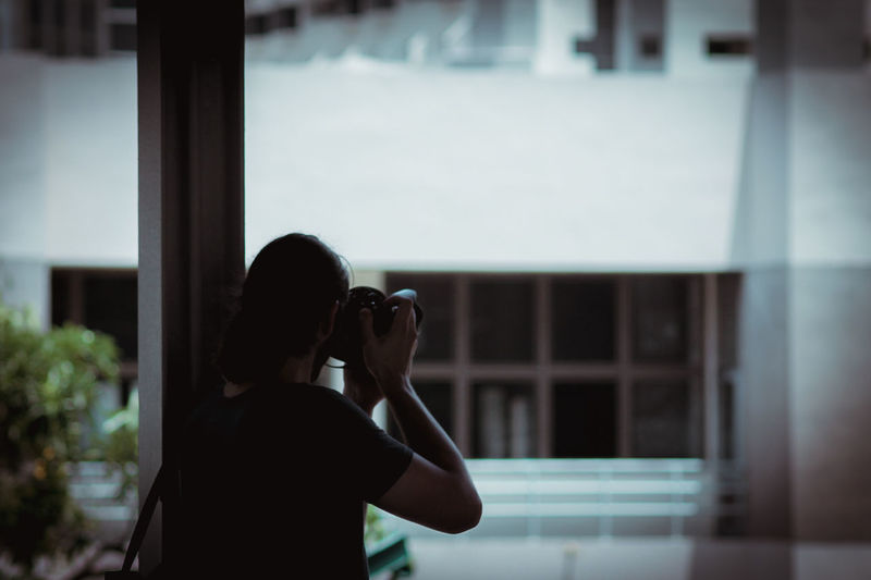 Close-up of woman photographing against building