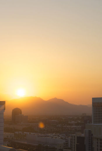 Cityscape against clear sky during sunset