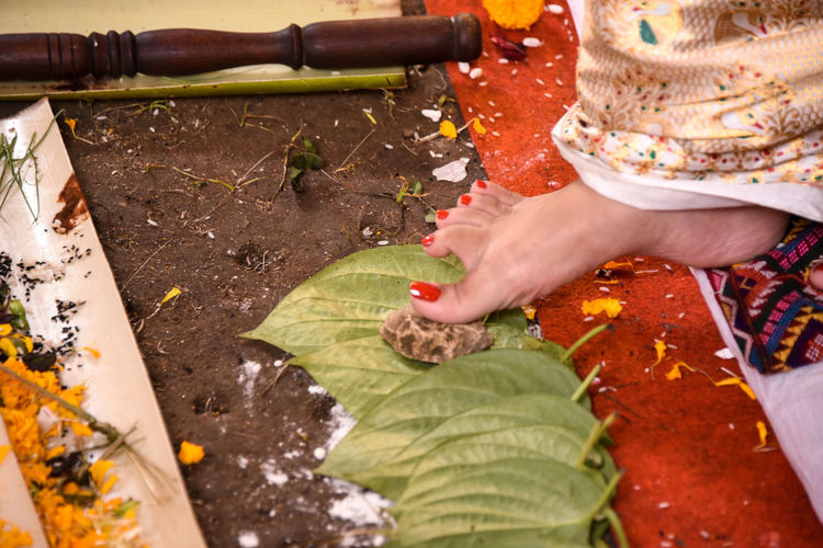 Close-up of bride touching areca nut with foot