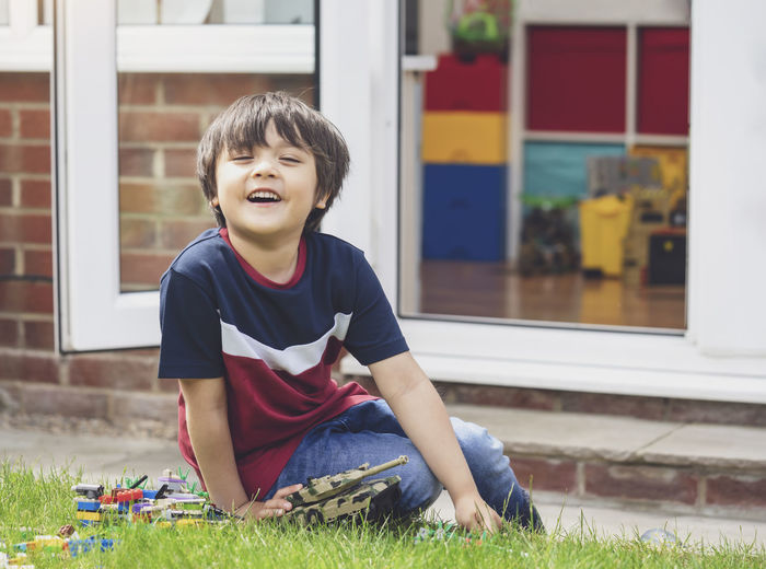 Smiling boy sitting in yard