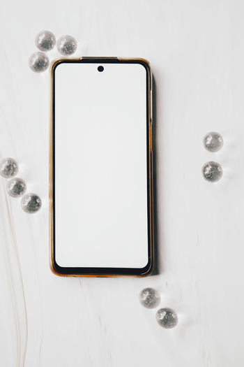 High angle view of mobile phone on white background