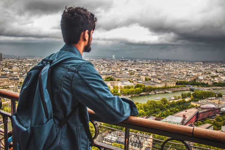 Man standing at observation point against cityscape