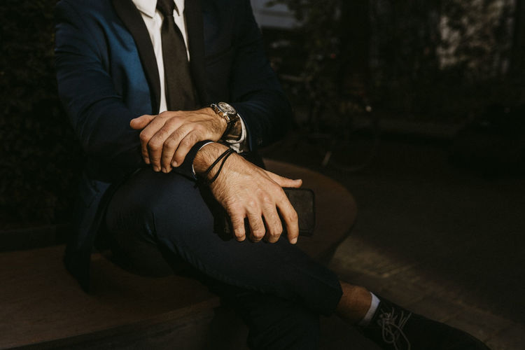 Low section of businessman sitting outdoors