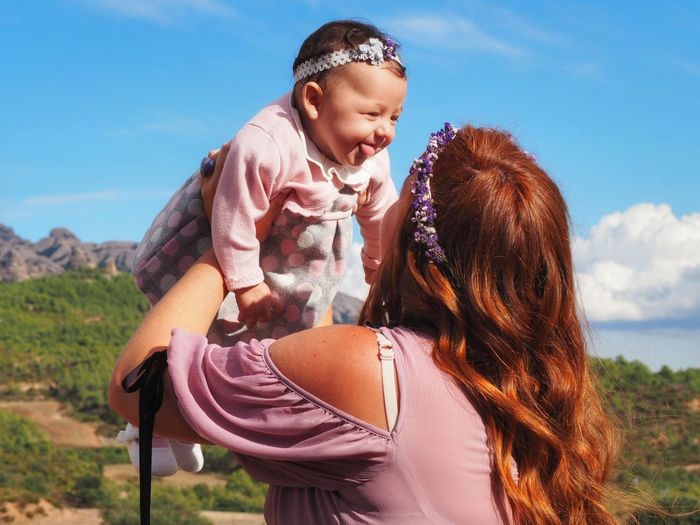 Happy mother and son against sky