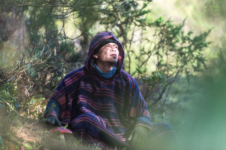 Portrait of colombian native american man in traditional clothing in forest