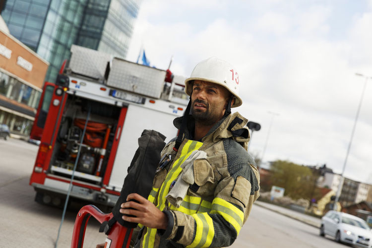 Firefighter standing by fire engine