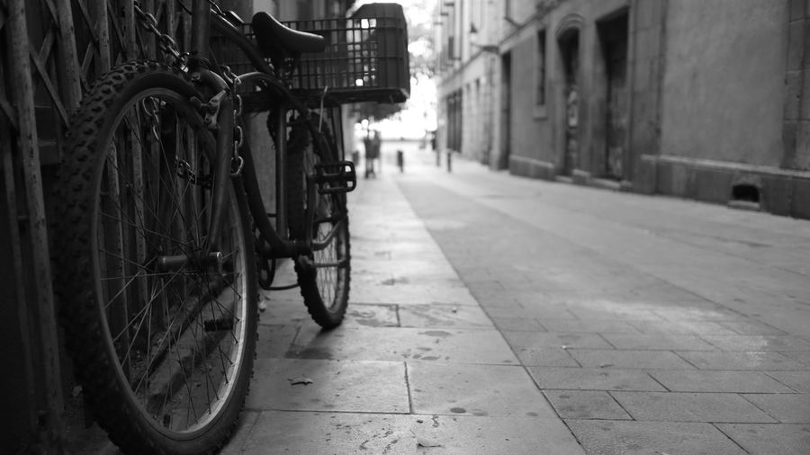Bicycle parked on street amidst buildings