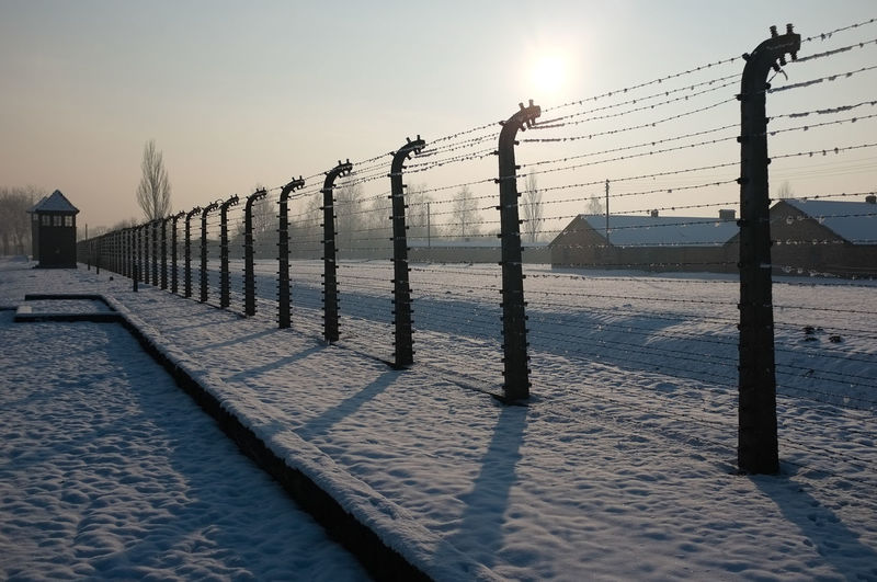 Fences with snow and long shadows at auschwitz concentration camp