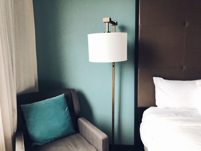 Electric lamp on bed against wall at the design hotel room