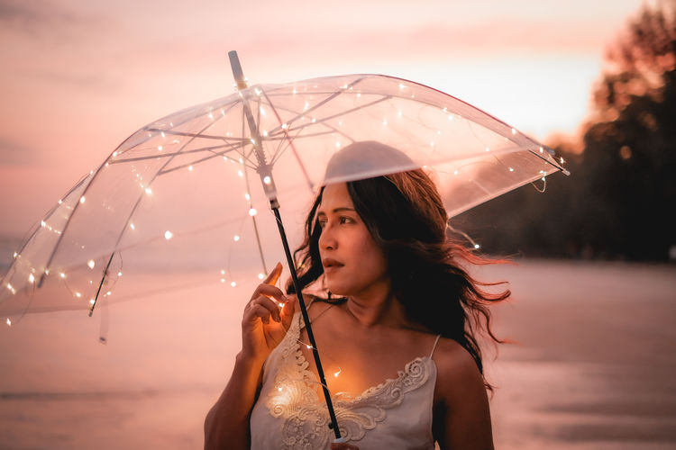 Portrait of woman holding wet umbrella