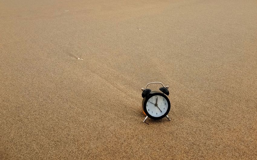 High angle view of clock on sand at beach