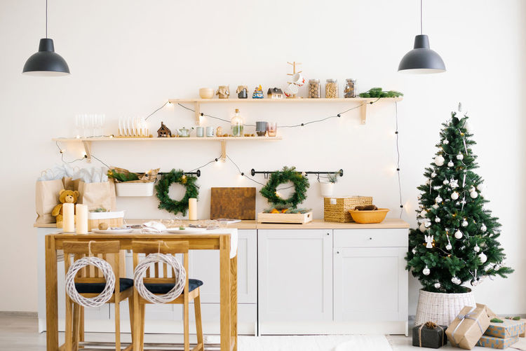 Scandinavian kitchen interior with dining tables decorated for christmas and new years.