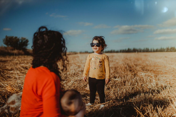 Cute girl wearing sunglasses standing on grassy land