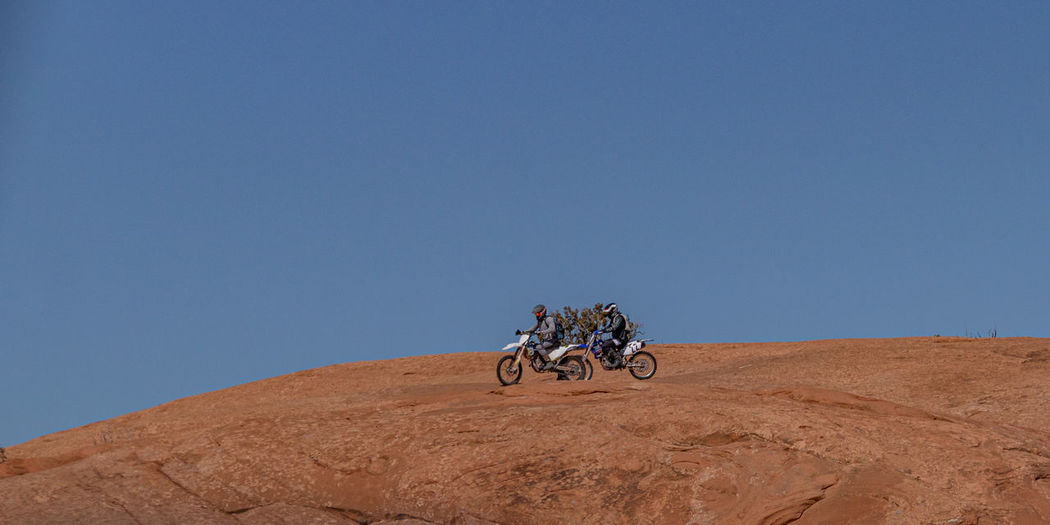 Full frame view of motorcyclists enjoying trail riding on sandstone on a perfect sunny day
