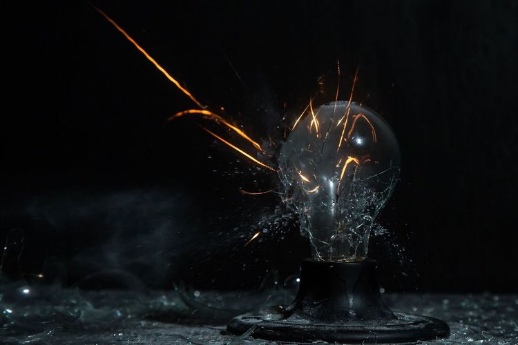Close-up of breaking light bulb with copy space