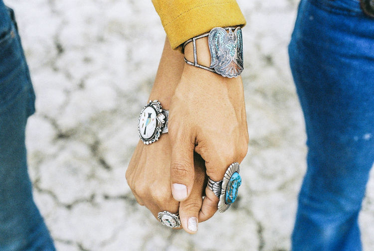 Cropped image of couple wearing antique jewelry while holding hands