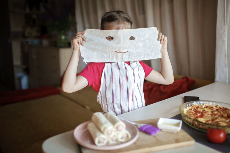 Girl covering face with wax paper