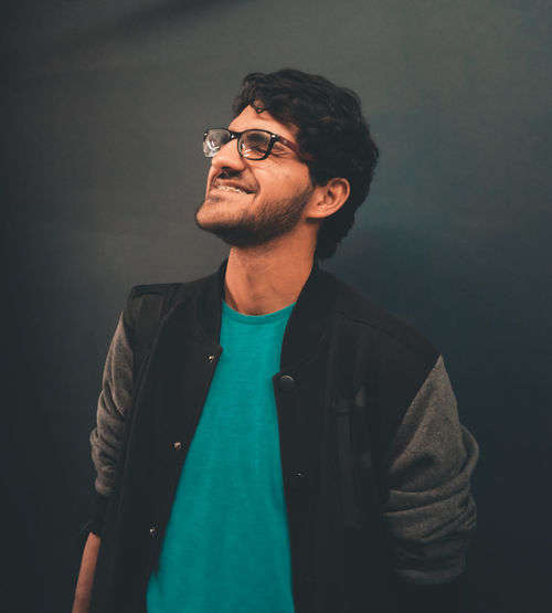 Young man standing against gray background
