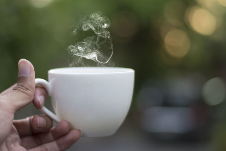 Close-up of hand holding coffee cup