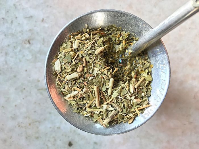 High angle view of herbs in mortar and pestle on table