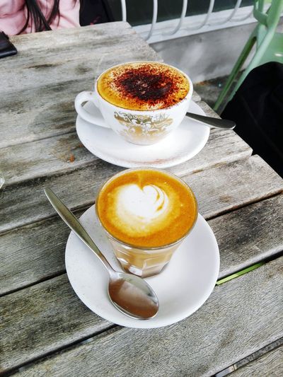 Close-up of man holding coffee cup on table