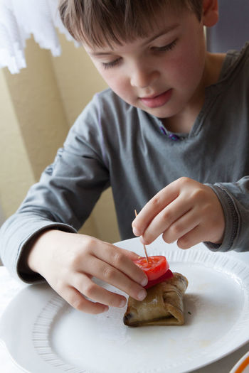 Boy preparing food at table in kitchen