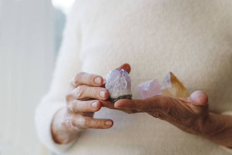 Hands of senior woman holding crystal stones