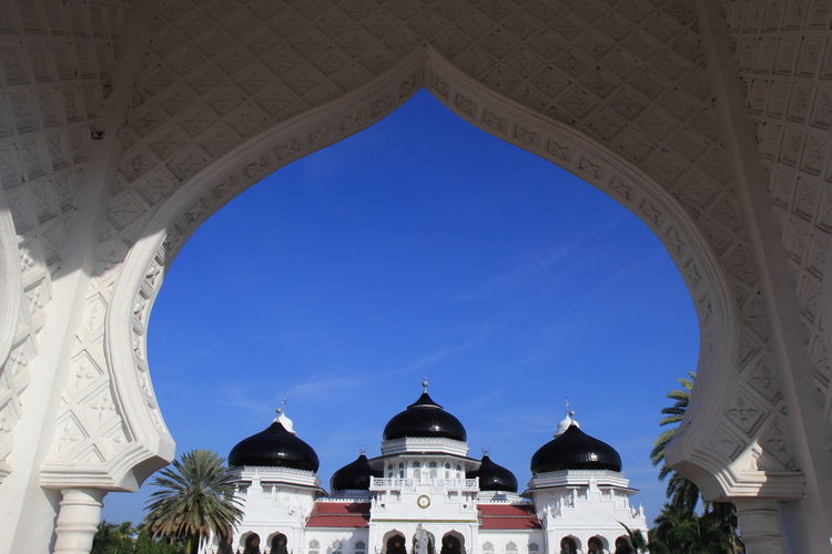Low angle view of baiturrahman grand mosque seen through arch