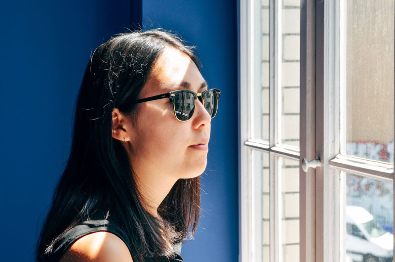 Beautiful woman looking through window