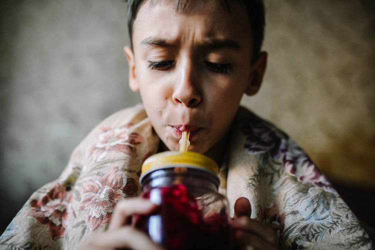 Close-up of boy drinking juice