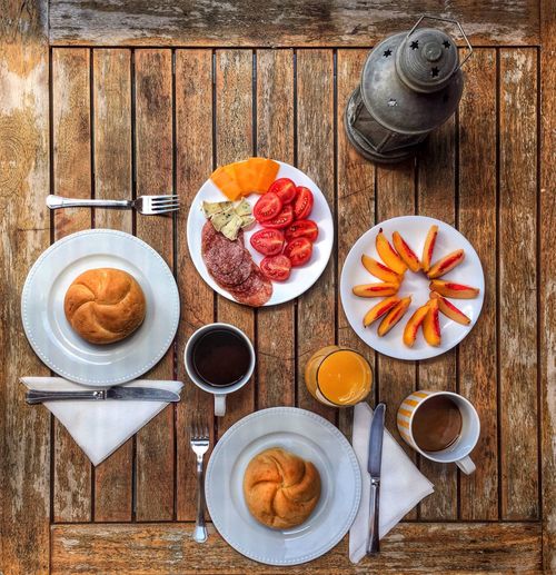 High angle view of breakfast in plates on wooden table