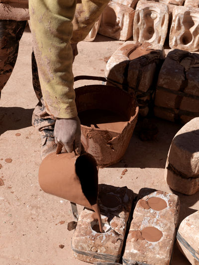 Low section of man making pottery in workshop
