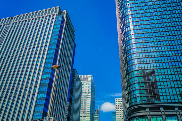 Low angle view of modern buildings against blue sky