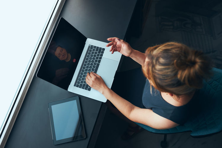 Midsection of woman using laptop at office