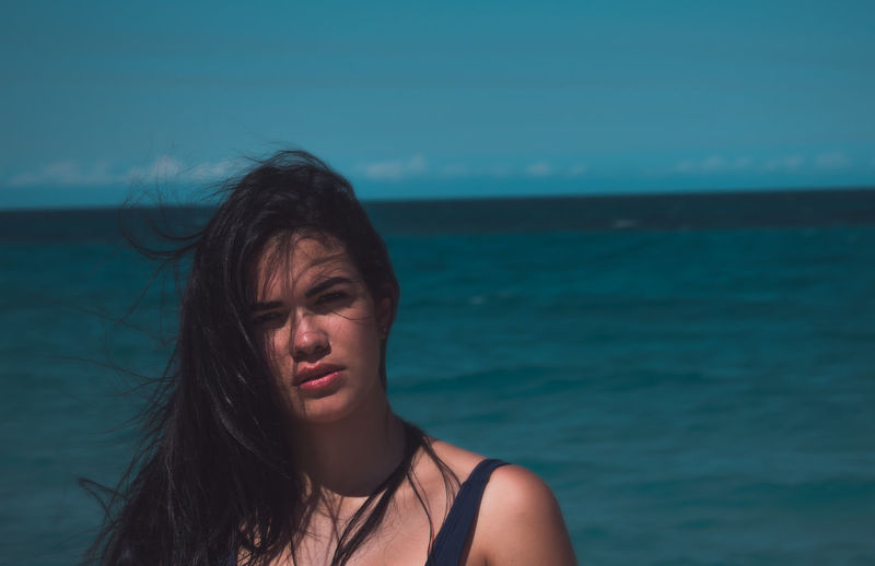 Portrait of beautiful woman against sea
