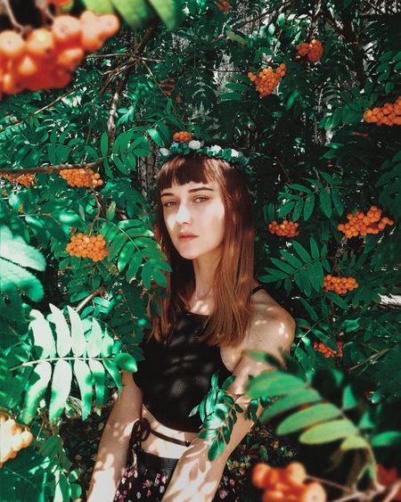 Portrait of beautiful young woman amidst plants
